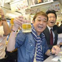 Passengers enjoy mugs of draft beer Thursday aboard a special Nagasaki streetcar that runs around the city serving beer and other beverages. The popular service is already fully booked through its last ride of the year on Sept. 20. | KYODO