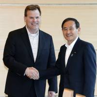 Chief Cabinet Secretary Yoshihide Suga greets Canadian Foreign Affairs Minister John Baird at the prime minister\'s office in Tokyo on Monday. | KYODO