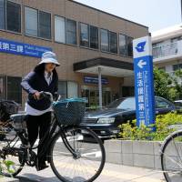 A cyclist rides by the public assistance section of the Edogawa Ward Office in Tokyo on Friday. | SATOKO KAWASAKI