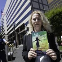 Uncomfortable truths: After writing a message to U.S. Ambassador to Japan Caroline Kennedy inside a copy of her book, Australian activist Catherine Fisher waits to present it to a member of staff at the U.S. Embassy in Tokyo on Friday. From Yokosuka rape to U.S. court victory, 'Jane' commits her 12-year ordeal to print