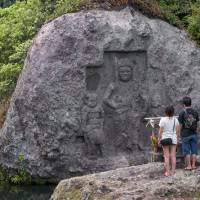 Stone worship: An ancient Buddhist triad image carved into a stone in the middle of a river at the center of the peninsula. | STEPHEN MANSFIELD