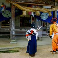 Praying before shooting: Two contestants in the festival pray at Togouchi’s Hori Hachiman shrine. | ANGELES MARIN CABELLO