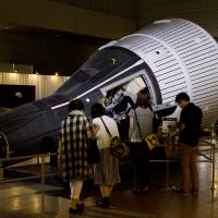 Attendees peek inside a replica command module. | BEN BRADY