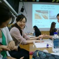 During an environmental event held on July at the Minato City Eco-Plaza, participants enjoy hand massages using coconut oil. | CHIHO IUCHI