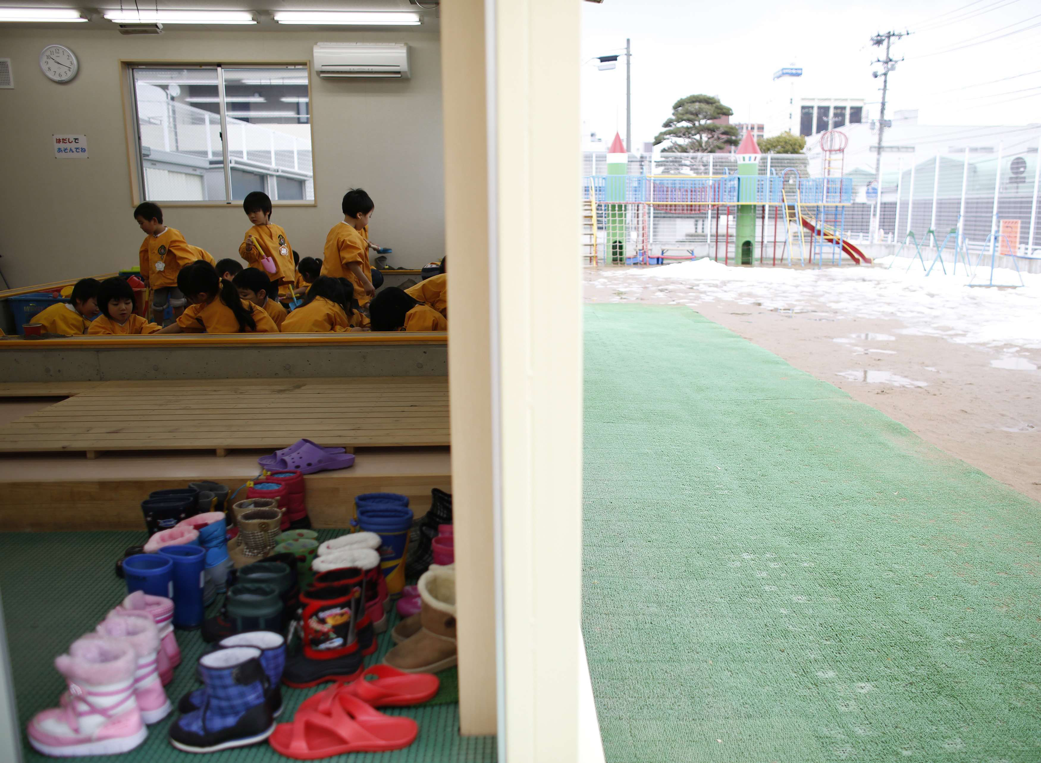 Playing it safe: Children play in an indoor sand pit at a kindergarten in Koriyama, about 50 km from the Fukushima No. 1 nuclear plant. The city recommended that children aged 3 to 5 limit their time outdoors to 30 minutes per day in the wake of the 2011 nuclear disaster. The limits were lifted in 2013, but many of the region's kindergartens continue to adhere to them because of parents' concerns. | REUTERS