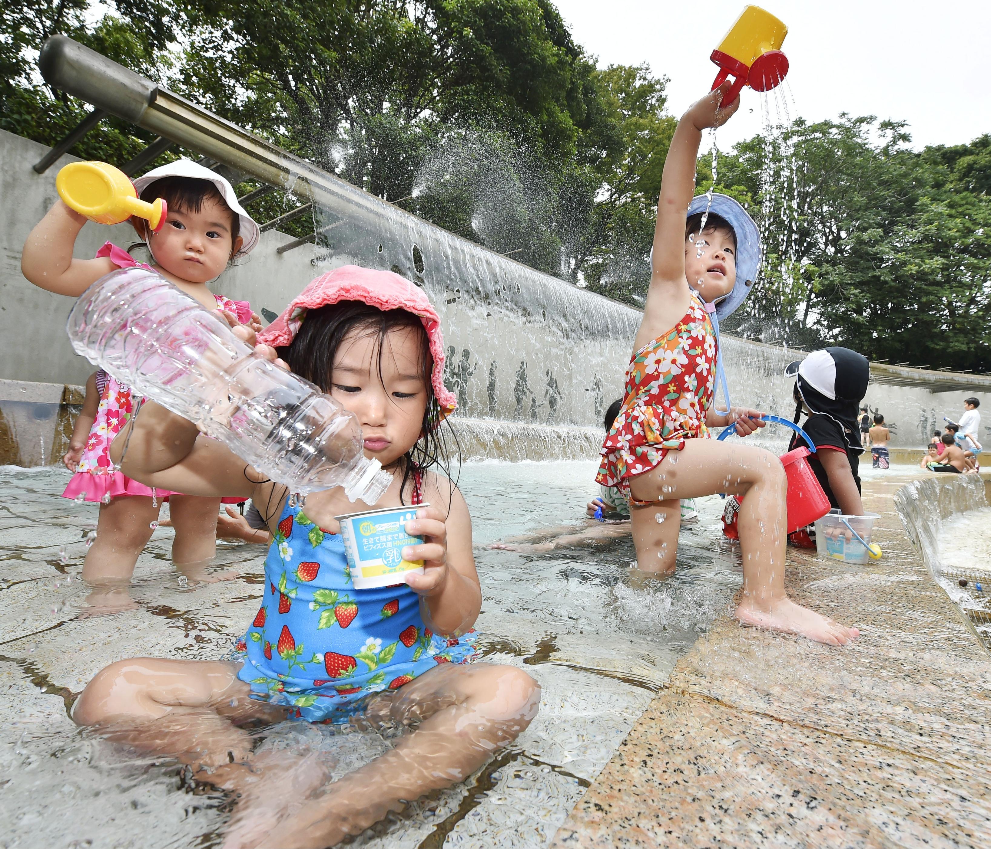 Children play with water in a fountain in Edogawa Ward, Tokyo, on Wednesday. Mercury hit the highest levels this summer in many areas of the nation. | KYODO