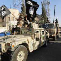 Militant Islamist fighters take part in a military parade along the streets of Syria\'s northern Raqqa province on Monday, to celebrate their declaration of an Islamic \"caliphate\" after the group captured territory in neighboring Iraq, a monitoring service said. | REUTERS