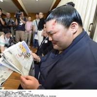 Talk of the town: Goeido reads Monday\'s newspapers after all but securing promotion to sumo\'s second-highest rank of ozeki at the Nagoya Grand Sumo Tournament on Sunday. | KYODO