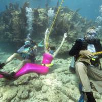 Nancy Barta, Samantha Langsdale and Fernando Barta (from left) play mock musical instruments at the Lower Keys Underwater Music Festival in the Florida Keys National Marine Sanctuary, at Looe Key Reef, on Saturday. Almost 500 divers and snorkelers tuned in to a local radio station\'s four-hour broadcast from beneath the sea via underwater speakers. | REUTERS