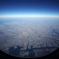 A view from an airplane window shows Haneda airport and the Keihin industrial area in Tokyo Bay. The government aims to sharply increase the number of overseas destinations for flights from Haneda and Narita airports to boost their international competitiveness. | BLOOMBERG