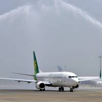 Fire hoses form an arch over a Spring Airlines Co. aircraft Friday at Narita International Airport during a ceremony to celebrate the budget airline\'s start of domestic flights. | KYODO