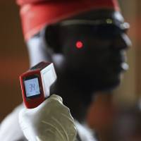 Authorities at Nnamdi Azikiwe International Airport in Abuja, Nigeria, are using remote thermometers to check the health of arriving passengers. Ten cases of Ebola have been reported in Lagos, with two deaths. The Liberian government, struggling with hundreds dead, says it will soon receive experimental drugs. | REUTERS