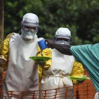 Medical staff with Doctors Without Borders prepare to bring food to patients kept in an isolation area at an Ebola treatment center in Kailahun, Sierra Leone, on July 20. | REUTERS