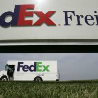 A Federal Express delivery truck leaves a distribution terminal in Edwardsville, Kansas. | AP