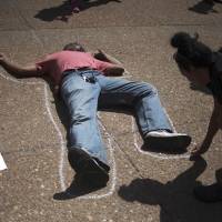 An activist outlines a man lying in front of City Hall in St. Louis on Tuesday. | REUTERS