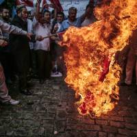Uighurs living in Turkey set on fire a representation of a Chinese flag outside the Chinese Consulate in Istanbul on Saturday as they stage a protest to condemn the killings of Uighurs allegedly killed in China\'s Xinjiang Uighur Autonomous Region. | AP
