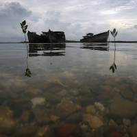 Decaying wrecks of confiscated foreign trawlers rot in a shallow estuary near Penagi, in Indonesia\'s Natuna archipelago, last month. | REUTERS