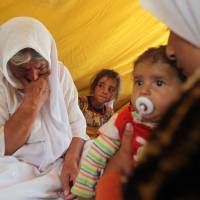 Refugees from the Yazidi religious minority gather in a tent at Newroz camp on Thursday in the province of Al-Hassakah in northeastern Syria. | AFP-JIJI