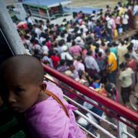 Passengers disembark from a ferry onto a jetty in Yangon on Saturday. Myanmar\'s first census in three decades shows the country has a population of 51 million people, around 9 million fewer than an earlier estimate. | AFP-JIJI