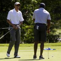 U.S. President Barack Obama laughs after Ahmad Rashad made a putt on the first green at the Farm Neck Golf Club in Oak Bluffs, Massachusetts, on Saturday. Obama is vacationing on the island for two weeks. | BLOOMBERG