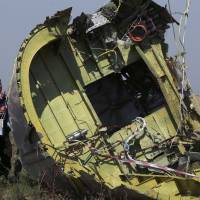 Members of a group of international experts on Friday inspect wreckage at the site near the village of Hrabove, in eastern Ukraine\'s Donetsk region, where the downed Malaysia Airlines Flight MH17 crashed to Earth in mid-July. | REUTERS