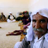 An Iraqi Yazidi family that fled the violence in the northern Iraqi town of Sinjar, sits at at a school where they are taking shelter in the Kurdish city of Dohuk in Iraq\'s autonomous Kurdistan region, on Tuesday. | AFP-JIJI