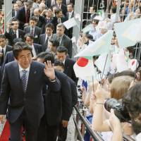 Prime Minister Shinzo Abe is welcomed at a party Saturday in Sao Paulo organized by a Japanese-Brazilian organization. | KYODO