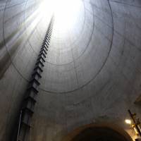 A worker looks up as he stands in an underground tunnel, part of the Furukawa reservoir project, under construction in central Tokyo on Aug. 7. When it is completed in 2016, the 3.3-km-long subterranean reservoir will be able to hold 135,000 cu. meters of water, enough to fill 54 Olympic-size swimming pools. | BLOOMBERG