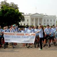 Anti-nuclear cyclists hold a banner urging U.S. President Barack Obama to abolish nuclear weapons by 2030, in Washington on Saturday, to coincide with the 69th anniversary of the U.S. atomic bombing of Nagasaki. | KYODO