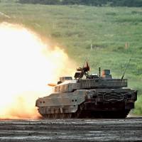 A Ground Self-Defense Force Type-10 tank fires live ammunition during a drill in Gotenba, Shizuoka Prefecture, on Sunday. | KYODO