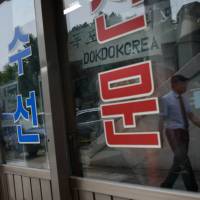 A \"Dokdo Korea\" sign is disaplayed in a stall on a street in Seoul on June 20. South Korea is giving more publicity to its claim to the islets it calls Dokdo, which Japan also claims and calls Takeshima. | AFP-JIJI