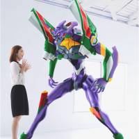 A woman stands next to a 2-meter sculpture of Evangelion Unit 01. Seven-Eleven Japan took orders Thursday for 25 of the figures, which cost &#165;1.83 million each, selling out in two minutes. | KHARA INC.