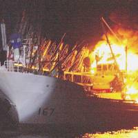 The fishing boat Kannon Maru No. 5 is engulfed in flames early Tuesday off Otsuchi, Iwate Prefecture. | JAPAN COAST GUARD/KYODO