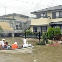 Shikoku firefighters rescue residents in a flooded area of Ino, Kochi Prefecture, on Sunday. | KOCHI SHIMBUN/KYODO