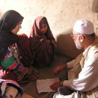Khaled Reshad provides health advice to a woman and a girl during a visit to a village, which at the time had no resident doctor, in rural Afghanistan in May 2004. | COURTESY OF KHALED RESHAD