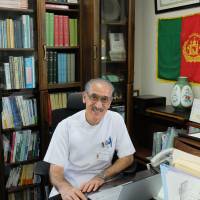 Khaled Reshad sits at his desk in his namesake Reshad Clinic in Shimada, Shizuoka Prefecture, on Aug. 5. | MAGDALENA OSUMI