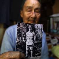 Former Imperial Japanese Army soldier Tokuro Inokuma, at his home in Yokosuka, Kanagawa Prefecture, shows a photograph of himself when he was 15 at an Imperial Japanese Army school in Mito, Ibaraki Prefecture, in 1944. | REUTERS