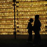 Paper lanterns provide the illumination during the annual Mitama Festival at Yasukuni Shrine in Tokyo on July 13. | REUTERS
