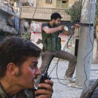 War zone: A photo by Shin Yahiro shows Free Syrian Army soldiers fighting with government forces Aug. 14 in the Salah ad-Din district in Aleppo. | SHIN YAHIRO