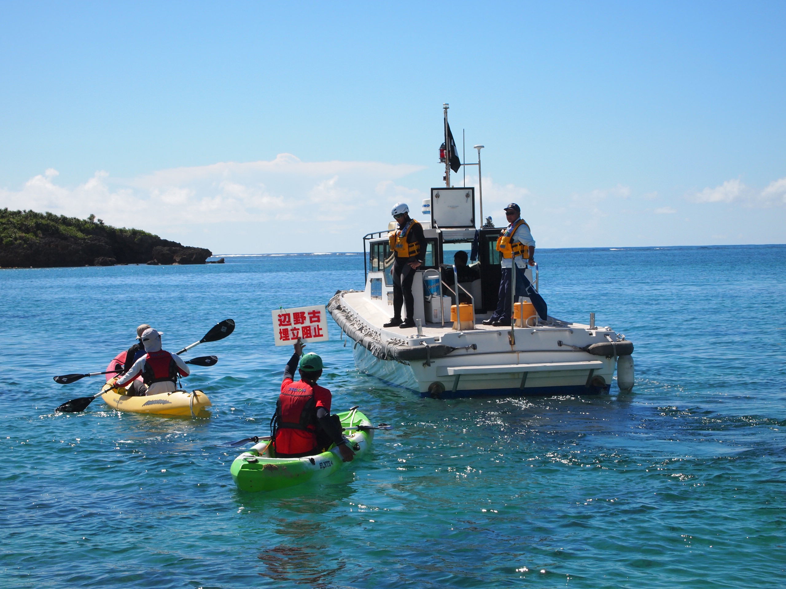 Protesters confront a Japan Coast Guard vessel in Henoko Bay, Okinawa, on Friday. | JON MITCHELL