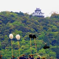 Pom-pom procession: People in traditional costume walk across Kintaikyo Bridge, with Iwakuni Castle in the background. | ANGELES MARIN CABELLO
