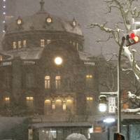 Into the white: Commuters leave Tokyo Station during a snowstorm on Feb. 8. | REUTERS