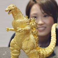A pure gold statuette of Godzilla is shown to the media Thursday at Kintetsu Department Store\'s flagship outlet in the Abeno Harukas skyscraper in Osaka. The 24-cm-tall figure of the cinematic icon is being sold for &#165;150 million. | KYODO