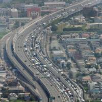 Traffic is backed up for kilometers Wednesday morning on the Chugoku Expressway near the Takarazuka interchange in Hyogo Prefecture. Congestion of roads, train stations and airports peaked Wednesday as people headed for their hometowns and other destinations during the mid-August Bon holiday. | KYODO