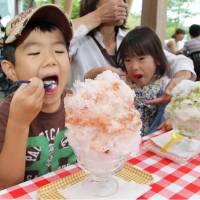 Children eat shaved ice made from naturally frozen ice at a shop in Nikko, Tochigi Prefecture. Following a traditional method that has lasted more than a century, blocks of ice gathered during the winter are stored until summer. | KYODO
