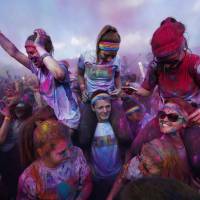 Participants covered in multicolored dyes at Sydney\'s Color Run are hoisted into the air Sunday. Inspired by the Hindu Holi festival, participants take part in a 5-km run dotted with locations where colored powders are thrown in a carnival atmosphere. | REUTERS