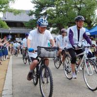 Cyclists participating in a nine-day relay race along the famous Shikoku Henro pilgrimage route covering 88 temples on the island kick off the race Friday at Zentsuji Temple in Zentsuji, Kagawa Prefecture. The temples are commemorating the 1,200th anniversary of their founding this year. | KYODO