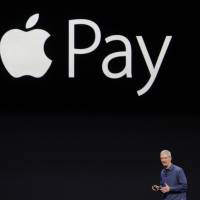 Tim Cook, chief executive officer of Apple Inc., unveils Apple Pay at Flint Center in Cupertino, California, on Tuesday. | BLOOMBERG