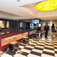 Press photographers (right) examine the entrance lobby on the \"transit side\" of Royal Park Hotel the Haneda at Tokyo\'s Haneda airport on Friday. | YOSHIAKI MIURA