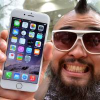 \"Mr. Butch\" displays his reward — a brand new iPhone 6 — for lining up early at one of Tokyo\'s SoftBank outlets. | AFP-JIJI